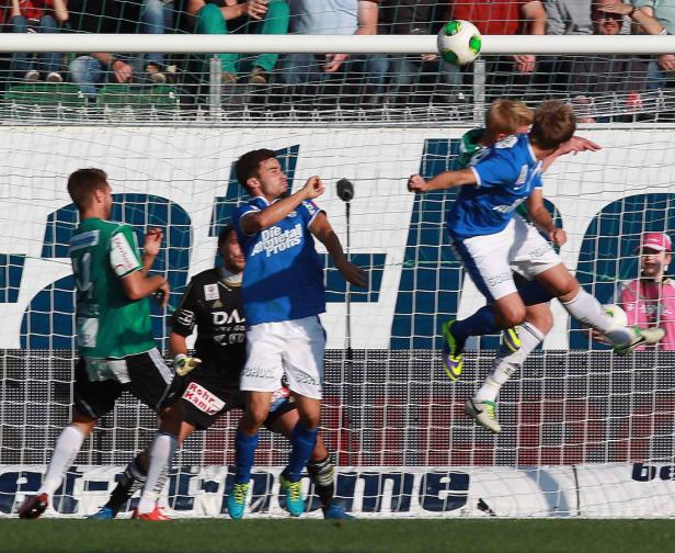Fußballspieler kämpfen um den Ball vor dem Tor.