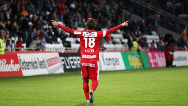 Ein Fußballspieler mit der Nummer 18 jubelt vor einer Zuschauertribüne.