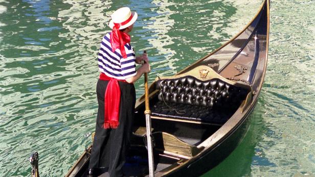 Ein Gondoliere in Venedig steuert eine Gondel.