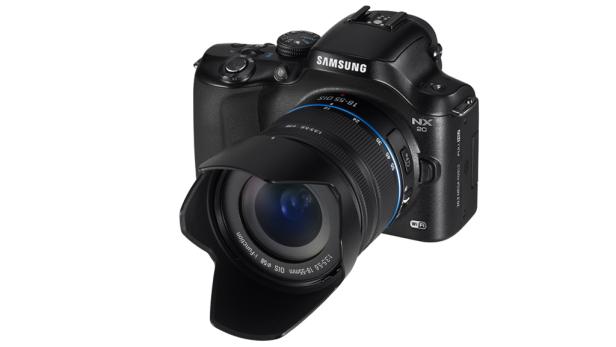 Eine schwarze Samsung NX20 Kamera mit einem 18-55mm Objektiv vor einem weißen Hintergrund.