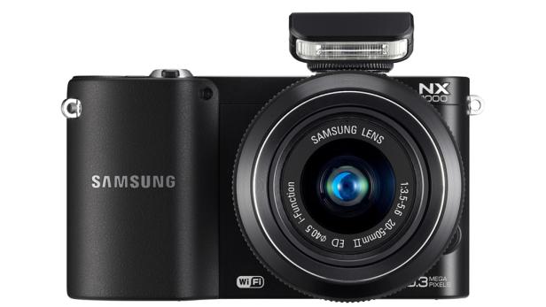 Eine schwarze Samsung NX2000 Kamera mit aufgesetztem Blitz.