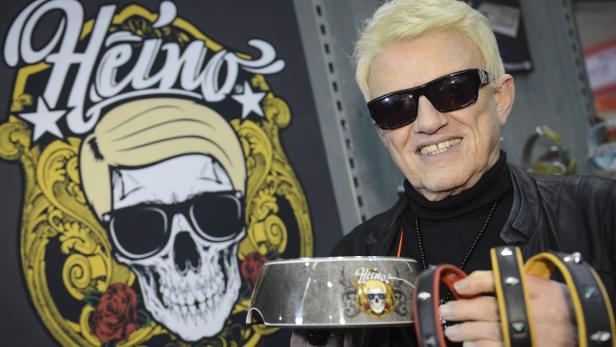 Heino präsentiert eine Hundeschüssel und Halsbänder mit seinem Logo.