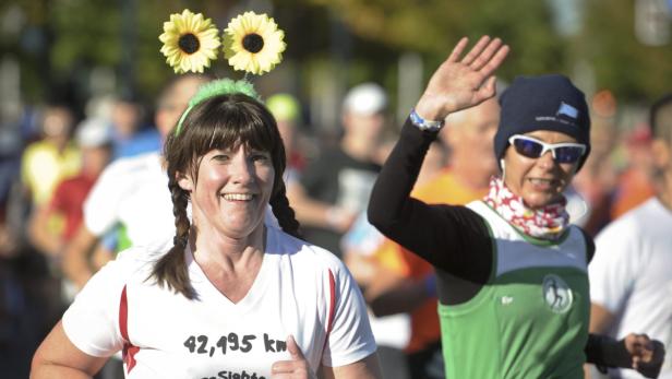 Zwei Frauen nehmen an einem Marathon teil, eine mit Sonnenblumen im Haar.