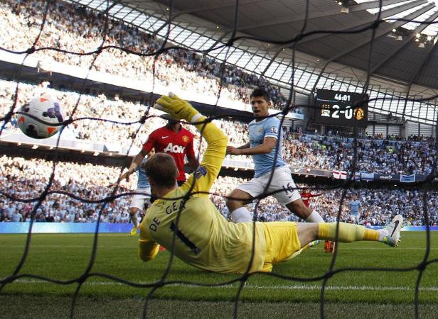 Ein Fußballspiel zwischen Manchester City und Manchester United, gesehen durch ein Tornetz.
