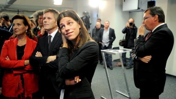 Eine Gruppe von Menschen steht aufmerksam in einem Raum.