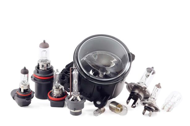 Verschiedene Arten von Glühbirnen und ein Scheinwerfer liegen auf einem weißen Hintergrund.