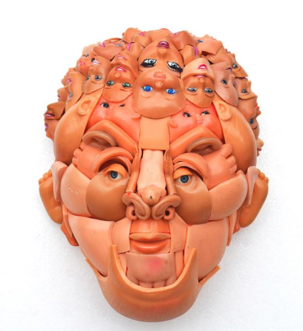 Eine skulpturale Darstellung eines Gesichts, zusammengesetzt aus Puppenteilen.
