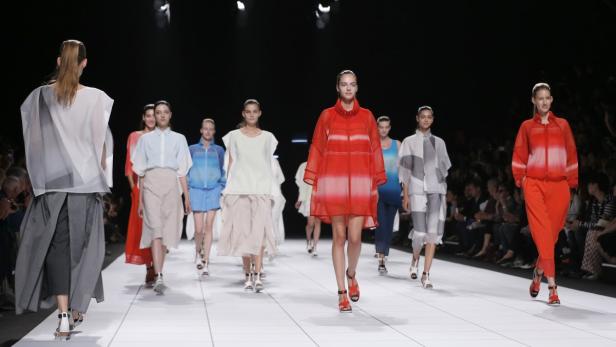 Models präsentieren farbenfrohe Mode auf einem Laufsteg.