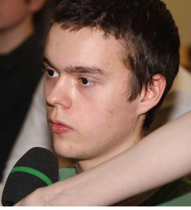 Ein junger Mann spricht in ein Mikrofon.