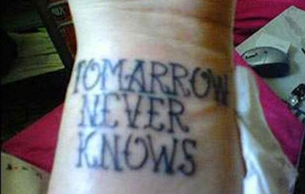 Ein Tattoo auf einem Handgelenk zeigt den Schriftzug „Tomorrow Never Knows“.