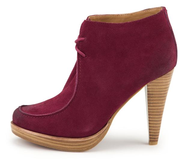 Ein burgunderroter Wildleder-Stiefelette mit hohem, holzfarbenem Absatz.