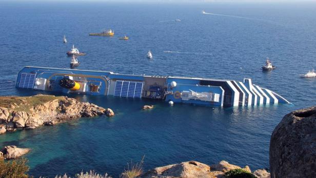 Das havarierte Kreuzfahrtschiff Costa Concordia liegt vor der Küste im Wasser.