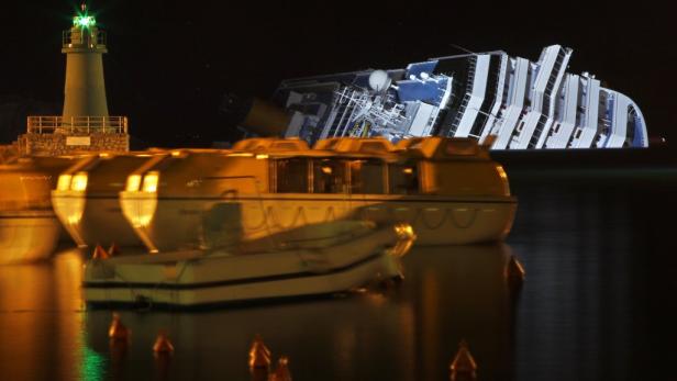 Die Costa Concordia liegt nachts gekentert vor der Küste.