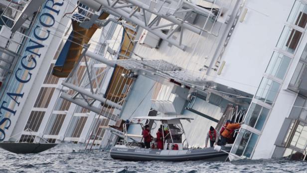 Die gekenterte Costa Concordia liegt im Wasser, während ein Rettungsboot sich nähert.