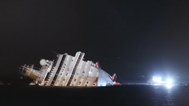 Die „Costa Concordia“ liegt nach dem Kentern im Dunkeln auf der Seite.
