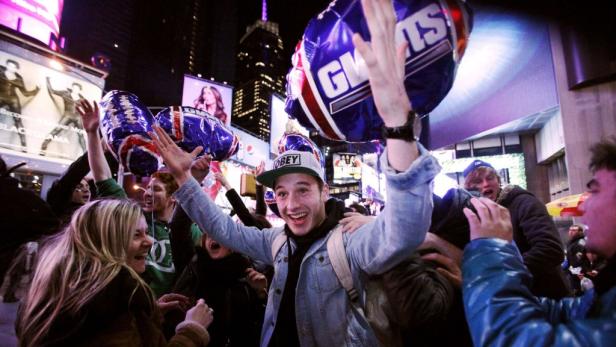 Feiernde Menschen mit „Giants“-Ballons auf dem Times Square in New York.