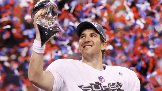 Eli Manning feiert mit der Trophäe nach dem Super Bowl Sieg.