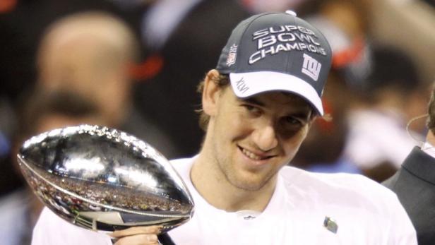 Eli Manning hält die Vince Lombardi Trophy nach dem Super Bowl XLVI Sieg.