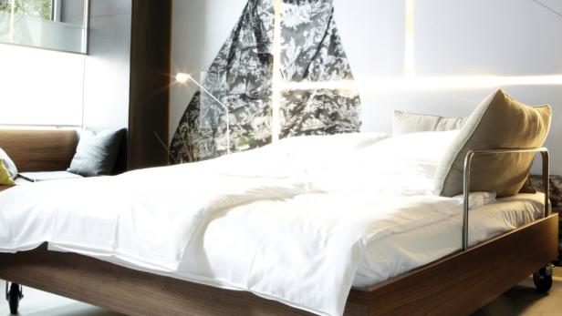 Ein modernes Schlafzimmer mit einem Holzbett und weißer Bettwäsche.