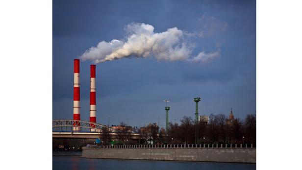 Zwei rot-weiß gestreifte Schornsteine stoßen Rauch in den Himmel aus.