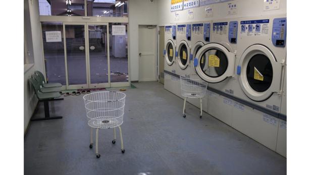 Ein Waschsalon mit mehreren Waschmaschinen und Wäschekörben.