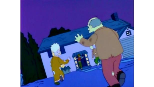 Zwei als Zombies verkleidete Personen gehen auf ein Haus zu, aus dem eine weitere Person kommt.