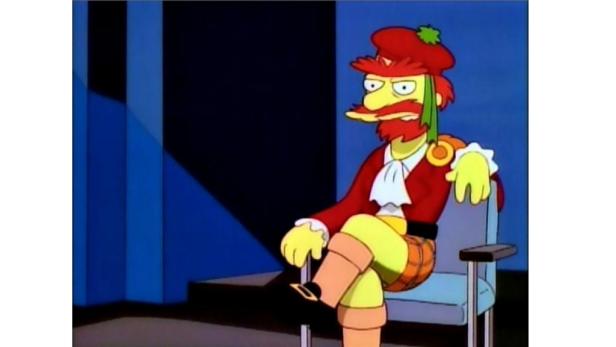 Willie aus „Die Simpsons“ sitzt in schottischer Tracht auf einem Stuhl.