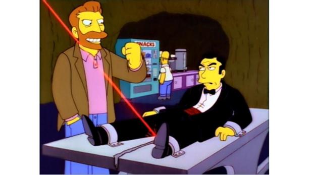 In einer Szene aus „Die Simpsons“ ist ein Mann an einen Tisch gefesselt, während ein anderer einen Laser auf ihn richtet.
