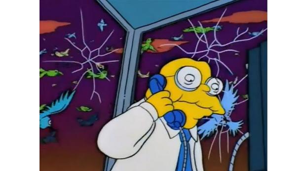 Ein gelber Mann mit Brille telefoniert vor einem Fenster mit Vogelschutzaufklebern und Rissen.