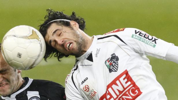 Ein Fußballspieler wird von einem Ball am Kopf getroffen.