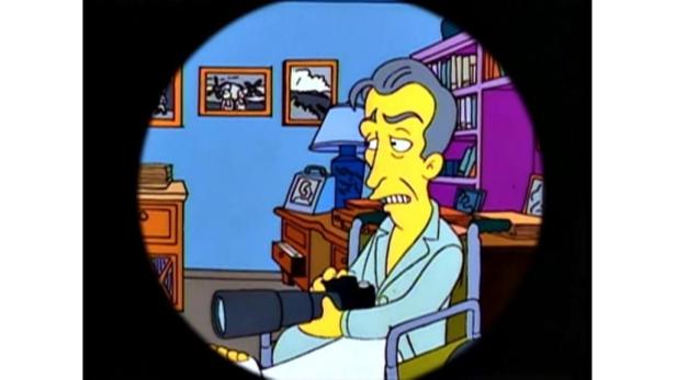 Ein älterer Mann im Rollstuhl blickt durch ein Teleskop.