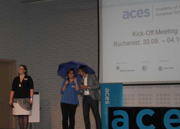 Drei Personen stehen auf einer Bühne während eines Kick-off-Meetings von ACES in Bukarest.
