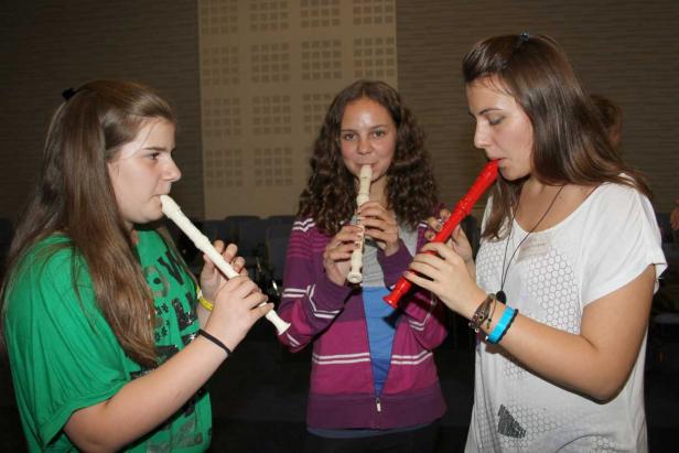 Drei junge Frauen spielen Blockflöte.