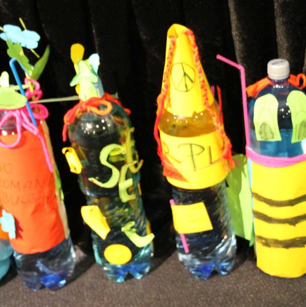 Kreative, dekorierte Wasserflaschen stehen auf einem Tisch.