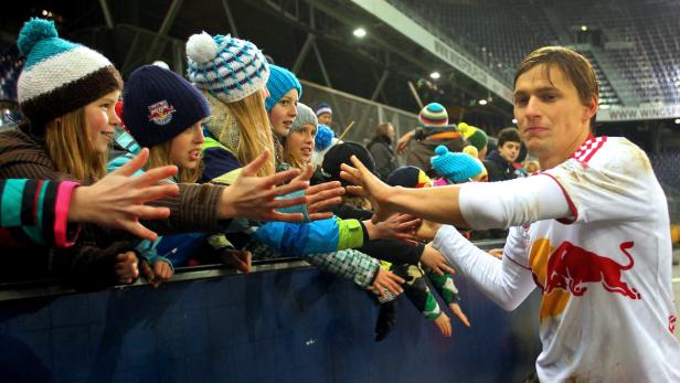 Ein Fußballspieler gibt Fans im Stadion ein High-Five.