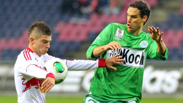 Zwei Fußballspieler kämpfen um den Ball während eines Spiels.