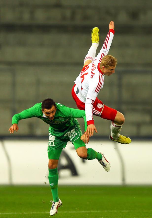Zwei Fußballspieler kämpfen um den Ball in einem Luftduell.