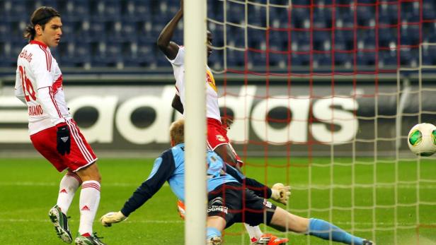 Ein Fußballspiel mit einem Torschuss und einem Torwart, der versucht, den Ball abzuwehren.