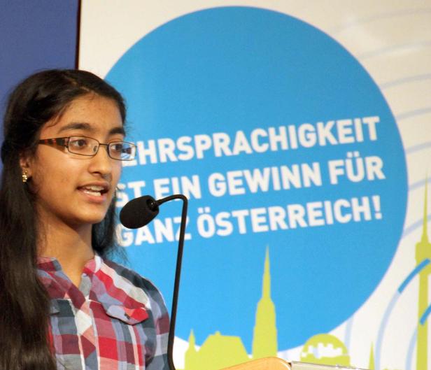 Ein junges Mädchen spricht bei einer Veranstaltung vor einem Mikrofon.