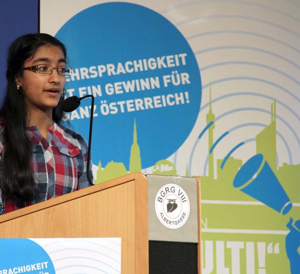 Ein junges Mädchen hält eine Rede vor einem Hintergrund mit Wiener Skyline.