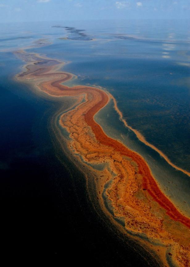 Eine orangefarbene Ölspur schlängelt sich über die Wasseroberfläche.