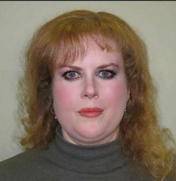 Eine Frau mit roten Haaren und blau-grauen Augen blickt in die Kamera.