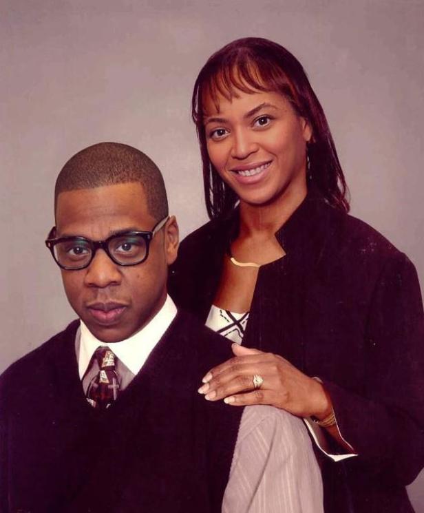 Ein Porträt von Jay-Z mit Brille und Beyoncé, die ihre Hand auf seine Schulter legt.