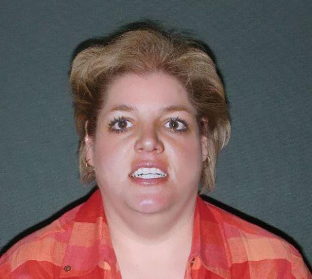 Eine Frau mit blonden Haaren und einem rot-karierten Hemd blickt in die Kamera.