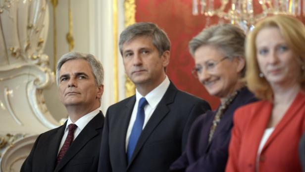 Eine Gruppe von vier Personen in formeller Kleidung steht zusammen.