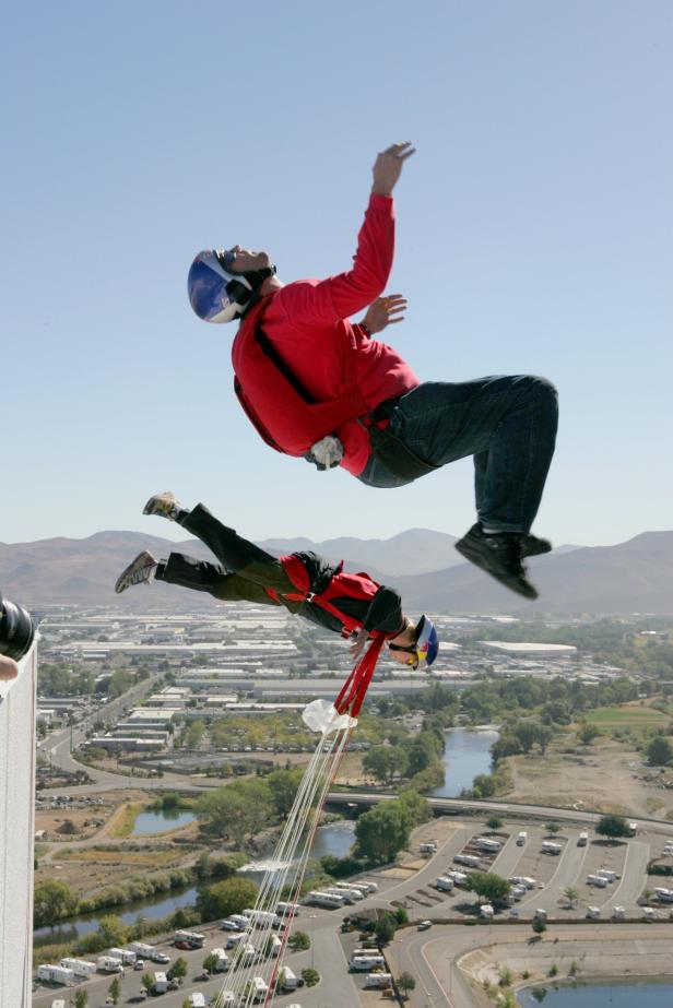 Zwei Basejumper springen von einem hohen Gebäude in die Tiefe.