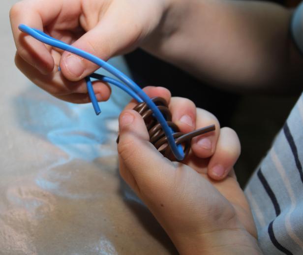 Ein Kind formt blaue und braune Knetmasse mit seinen Händen.