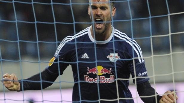 Ein Fußballspieler von Red Bull jubelt hinter einem Tornetz.