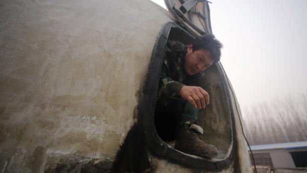 Ein Mann steigt in eine kleine, kuppelförmige Struktur.