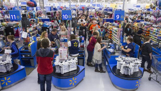 Kunden stehen an den Kassen eines vollen Walmart-Geschäfts an.